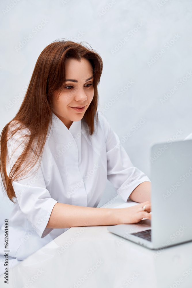 female doctor in white medical uniform using laptop female doctor in white medical uniform using laptop