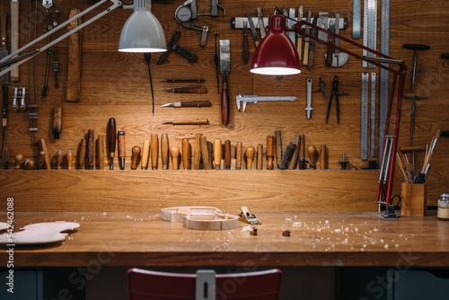 Workbench of luthier with unfinished violin and tools photo