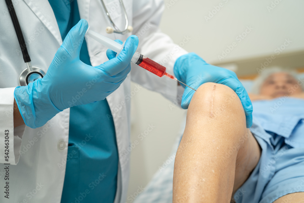 Asian doctor inject Hyaluronic acid platelet rich plasma into the knee of senior woman to walk without pain. Asian doctor inject Hyaluronic acid platelet rich plasma into the knee of senior woman to walk without pain.