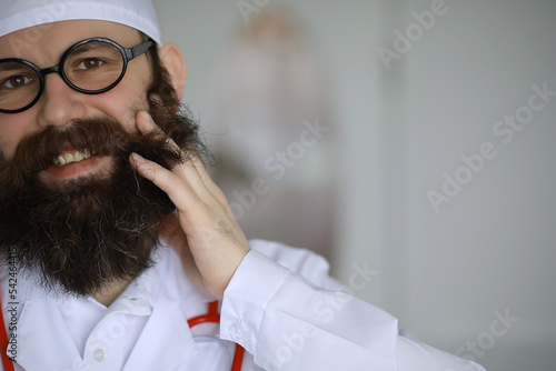 Doctor crazy. A mad beard scientist conducts experiments in a scientific laboratory. Performs research using syringe and a stethoscope.