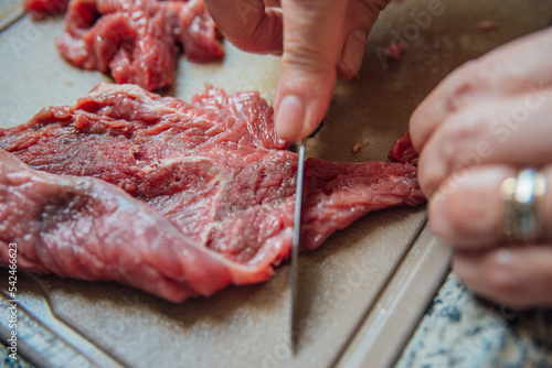Mulher cortando carne de boi