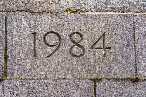 Close-up of stone wall at City of Zürich with year 1984 engraved on a sunny autumn day. Photo taken October 30th, 2022, Zurich, Switzerland.