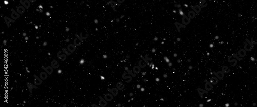 Falling snow isolated on black background. Falling snow at night. Bokeh lights on black background  flying snowflakes in the air. Winter weather. Overlay texture.