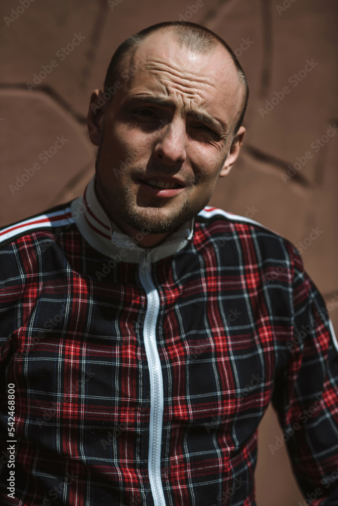 male portrait on the street in sunlight; dressed in a red and black suit male portrait on the street in sunlight; dressed in a red and black suit
