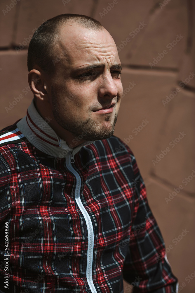 male portrait on the street in sunlight; dressed in a red and black suit male portrait on the street in sunlight; dressed in a red and black suit