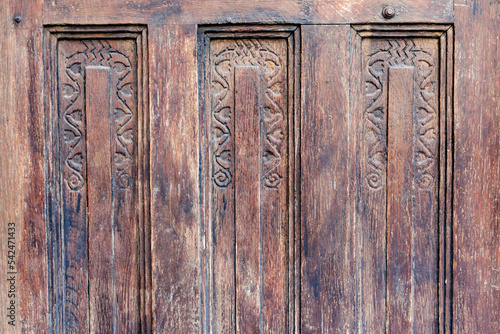 Close up to an old weathered wood door with rustic model or design