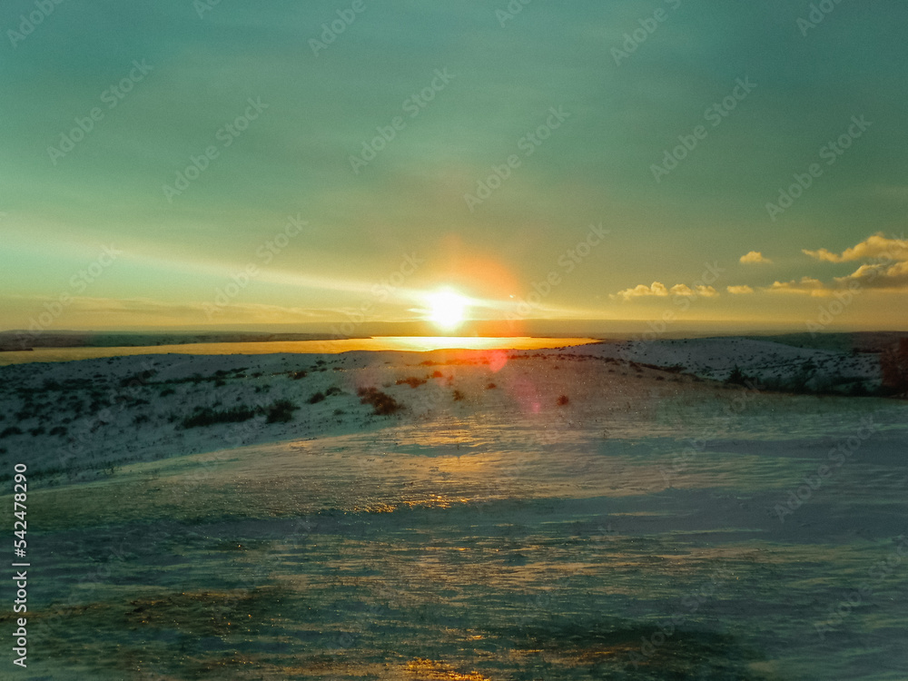 Obraz premium Yellow and blue sunset over snowy landscape