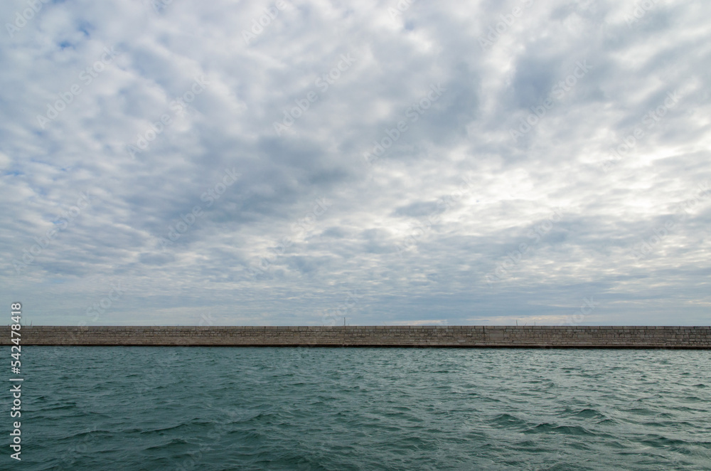 La Diga Foranea che unisce l'isola di Pellestrina a Ca' Roman sotto un cielo nuvoloso in una giornata d'inverno