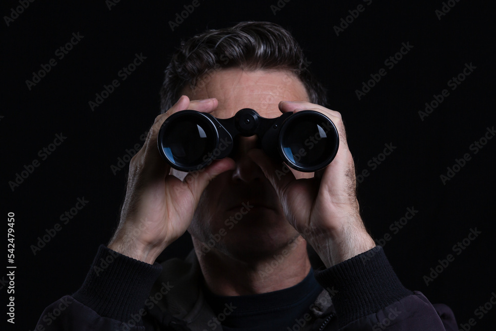 Binoculars espionage in a dark background Binoculars espionage in a dark background