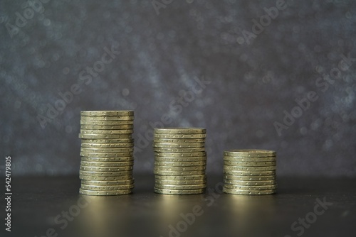 Closeup of three stacks of coins decreasing in number from left to right