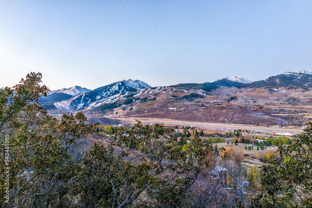 Aspen highlands in Colorado with colorful pastel blue blue twilight sunset in rocky mountains roaring fork valley with late season autumn foliage transition to winter