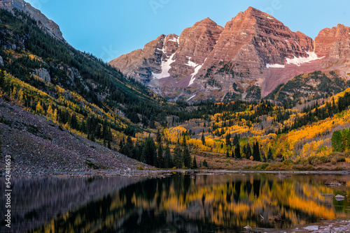 Maroon Bells peak and lake at sunrise in Aspen, Colorado rocky mountains in October autumn fall season trees reflection on water surface © Kristina Blokhin