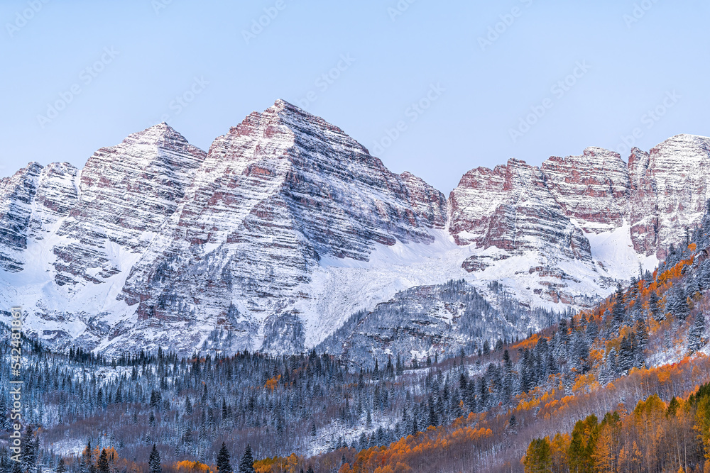 Closeup of Maroon Bells at sunrise dawn in Aspen, Colorado of Elk range mountain with Rocky mountains in late autumn with winter snow covered peak