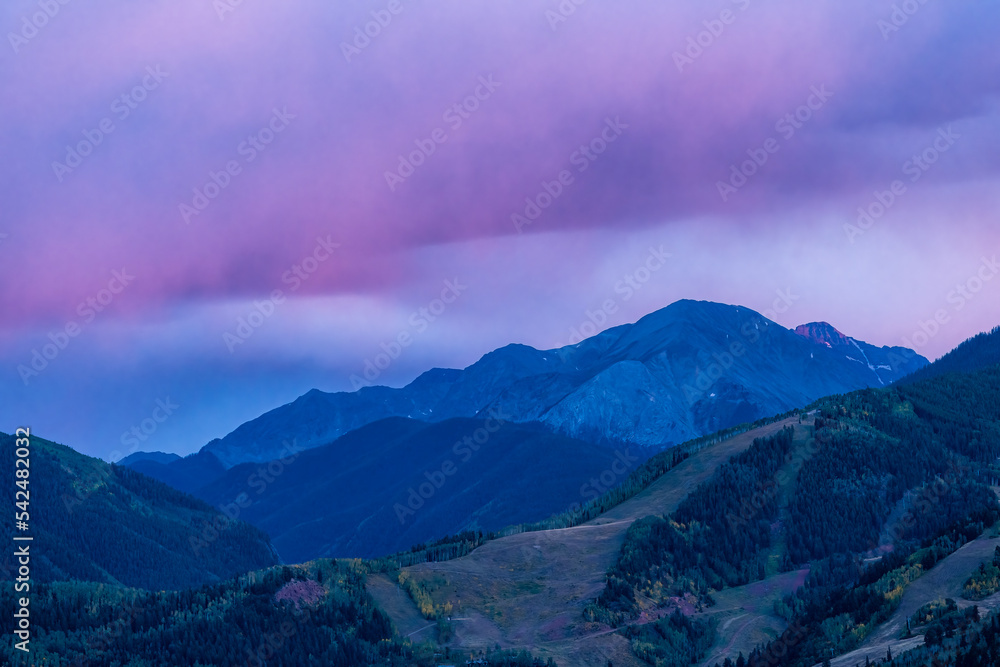 Pink purple sunset in Aspen, Colorado with Rocky mountains of Buttermilk ski slope mountain in autumn with pastel color twilight sunset or dusk