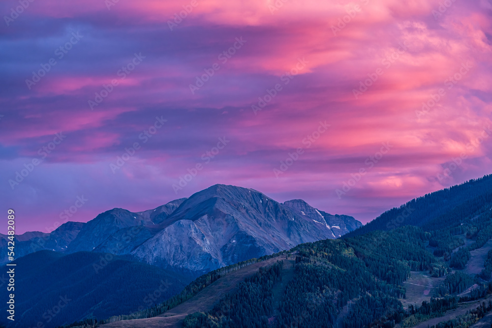 Pink purple colorful sunset in Aspen, Colorado with Rocky mountains of Buttermilk ski slope mountain in autumn fall with twilight sunset