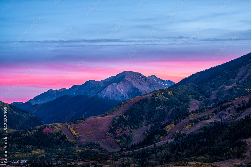 Pink purple sunset in Aspen, Colorado with Rocky mountains of Buttermilk ski slope mountain in autumn fall with pastel color twilight sunset or dusk