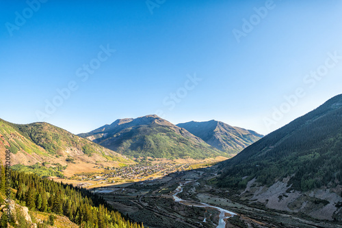 Wide angle aerial high angle view of Silverton, Colorado small mining town from overlook and morning sunrise sun in sky at autumn
