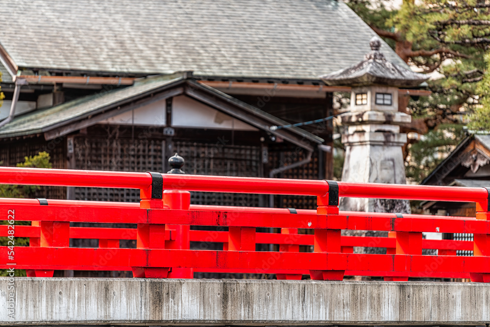 Red vermilion color bridge railing over Enako river Stone paved path footpath in Takayama, Japan at Higashiyama walking course in historic city of Gifu Prefecture by Tounin temple shrines Red vermilion color bridge railing over Enako river Stone paved path footpath in Takayama, Japan at Higashiyama walking course in historic city of Gifu Prefecture by Tounin temple shrines