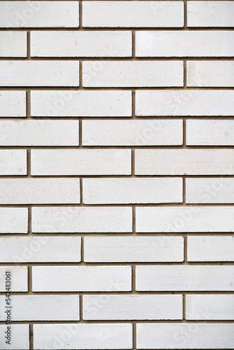 Vertical photo of a white brick wall