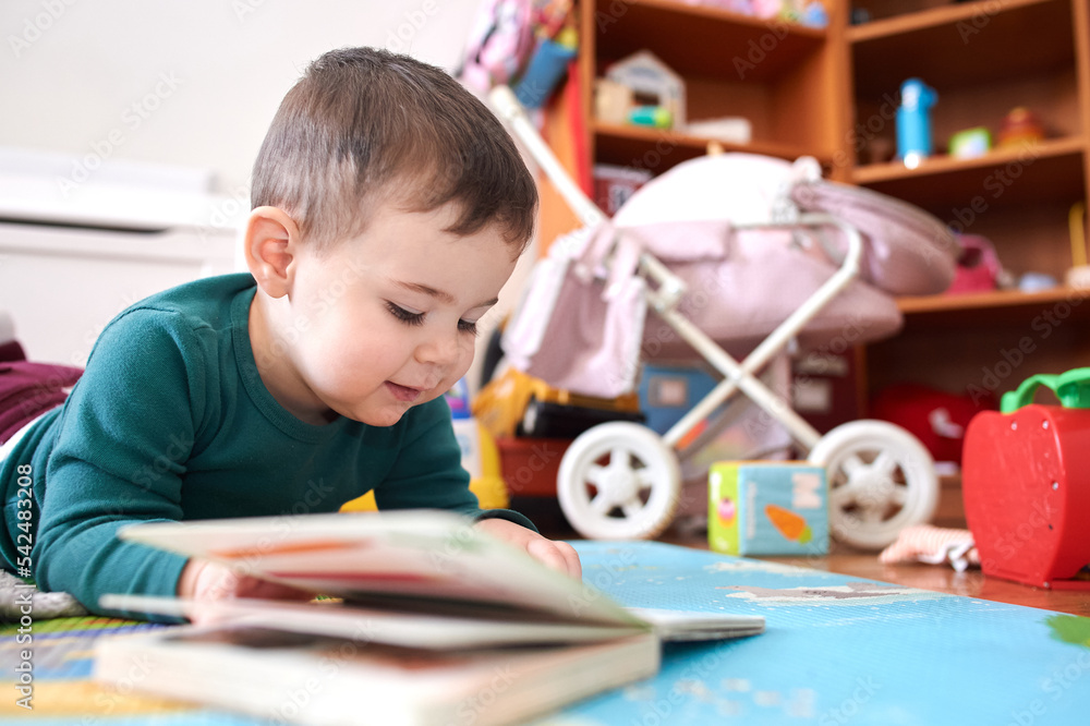 Fototapeta premium young boy playing and looking at books in his room