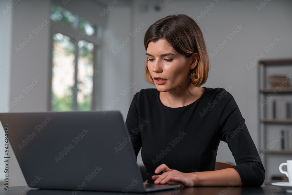 Inspired attractive businesswoman is typing on laptop at office workplace Inspired attractive businesswoman is typing on laptop at office workplace