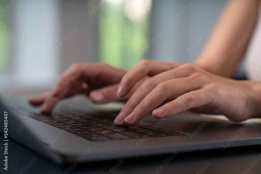 Businesswoman is sitting typing on laptop at office workplace Businesswoman is sitting typing on laptop at office workplace