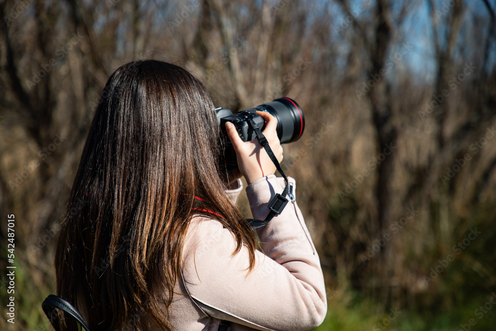 Beautiful woman taking a picture of a dry trees forest Beautiful woman taking a picture of a dry trees forest