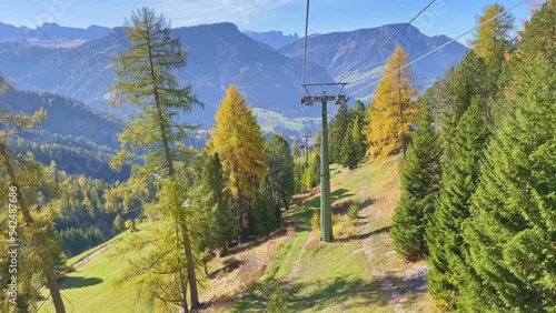 Travel video Seceda ropeway in Dolomites with Autumn Leaves background A wonderful view of Seceda mountains, dolomites, italy, Cable Car moving down the mountain with beautyful view in sunny day photo