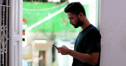 Candid man holding cellphone device. Person staring at smartphone screen