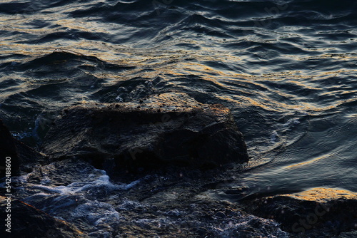 blue waves hitting rocks during golden hour