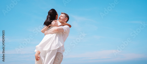 Young couple in love outdoor. Happy man Hugging and laughing to his woman romantic at tropical beach. Girlfriend with boyfriend resting travel at sunrise in summer.