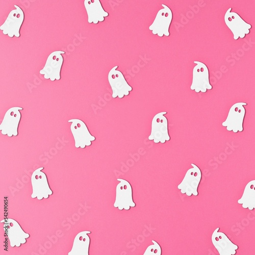 White ghost pattern on the pink background. The Halloween concept. Flat lay