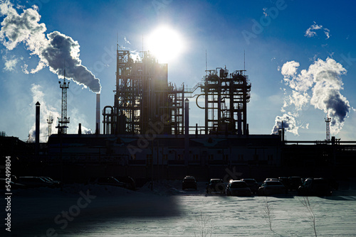 Oil refinery plant against the backdrop of bright winter sun.