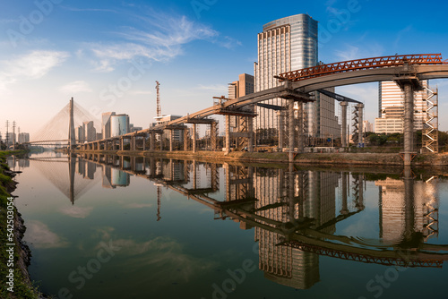 View of Pinheiros River With Modern Buildings Alongside and Famous Octavio Frias de Oliveira Bridge in Sao Paulo City photo