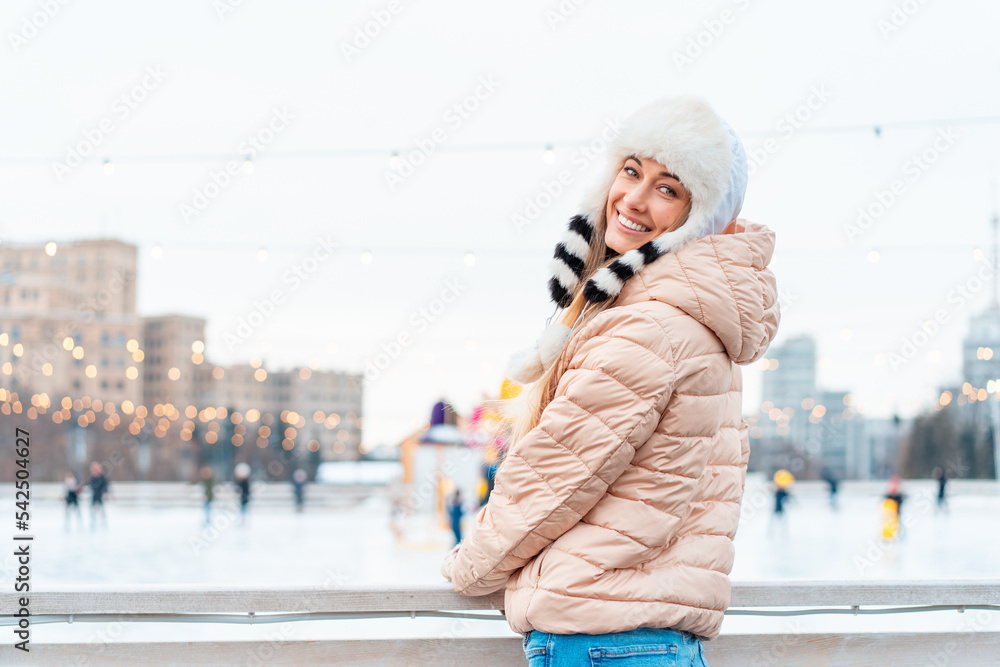 Happy winter time in big city charming girl standing street dressed funny fluffy hat. Enjoying snowfall, expressing positivity, smiling to camera