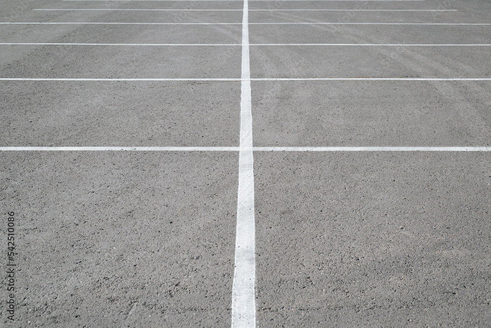 Empty parking place, row of white lines marking parking spaces on asphalt, outdoor carpark