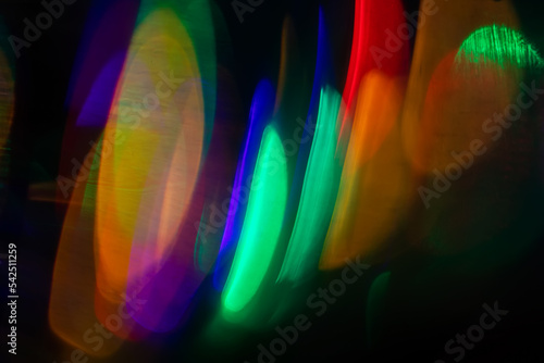 Blurred Light painting one exposure in camera. light glares with a spectral gradient on a dark background.