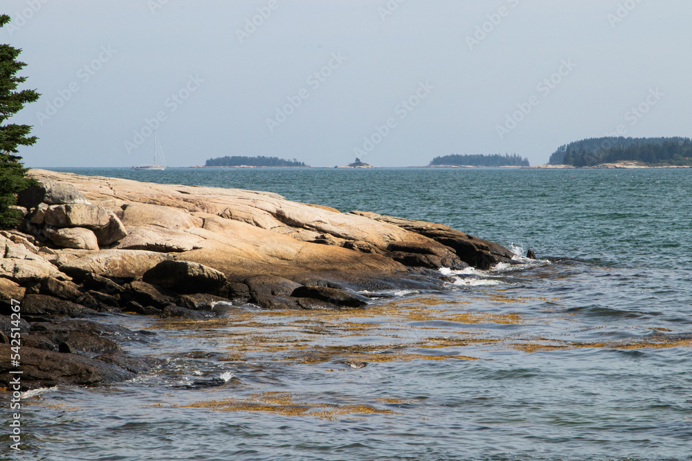 Rock formation on the water with islands in the background
