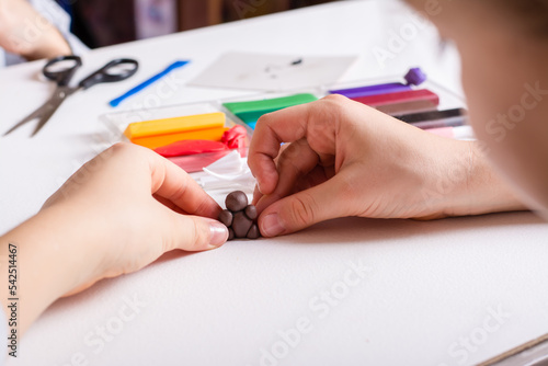 Children's hands make a bear out of polymer clay. Handmade and leisure. photo