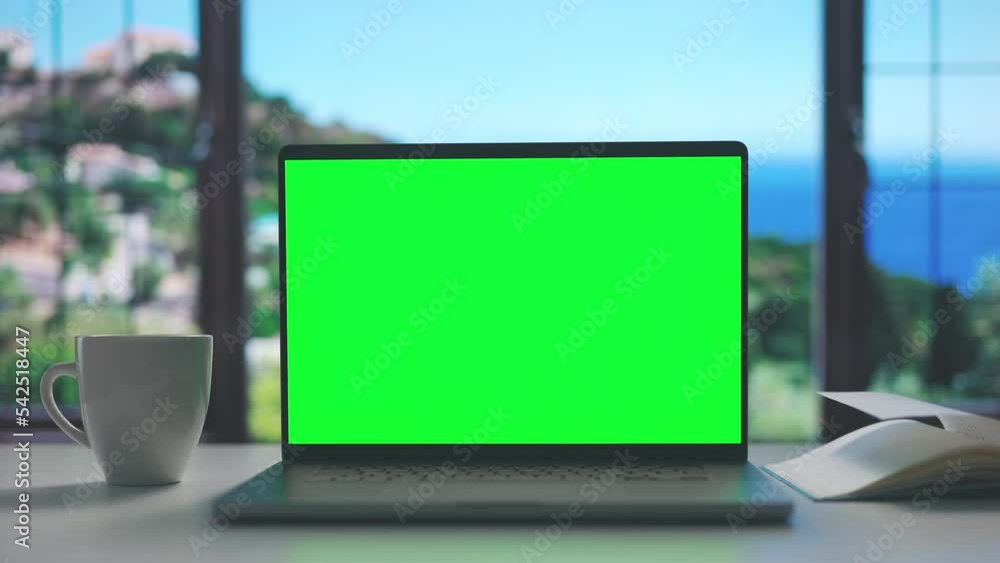 Comfortable working place near seaside window, laptop with chroma screen for copy space, coffee cup and notepad Comfortable working place near seaside window, laptop with chroma screen for copy space, coffee cup and notepad