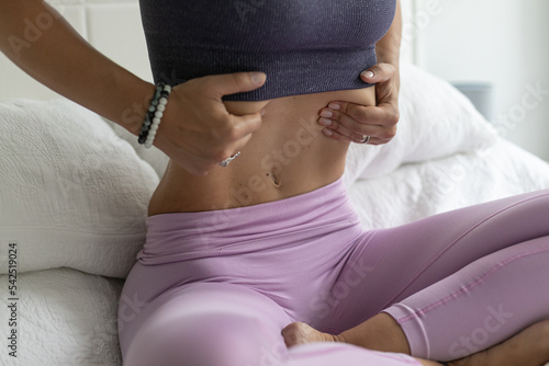  young woman with beautiful body doing uddiyana bandha asana yoga in bed at home practicing vacuum photo