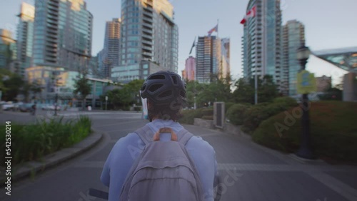 Man cycling through vancouver city at sunset, british columbia
