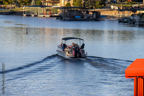 Tableau sur toile pontoon boat with canopy cruising on lake