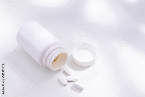 Comprimidos brancos em fundo branco com sombras photo