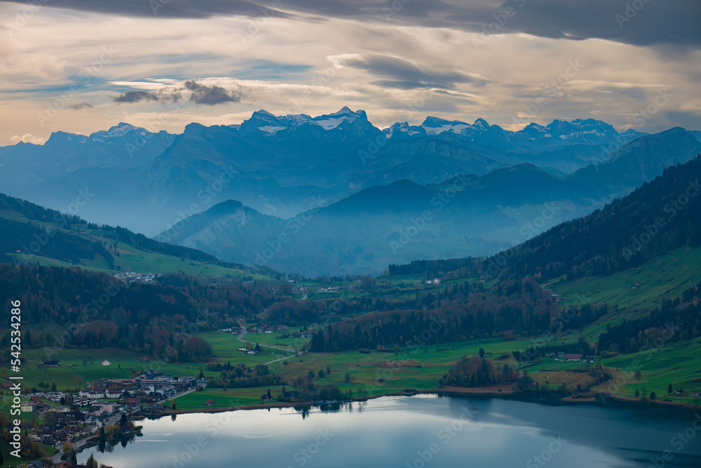 Foggy Autumn landscapes in central Switzerland with the Aegeri lake in the foreground and the bernese highlands in the distant background, Canton Zug