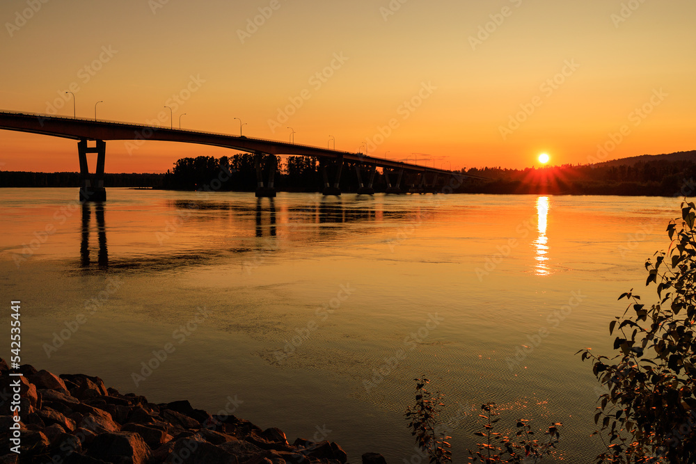 Bridge over river during beautiful orange sunset