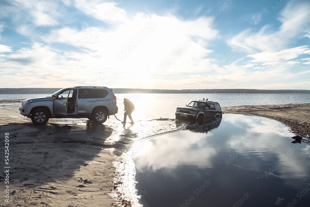 offroad vehicle trying to pull a stuck offroad vehicle out of the