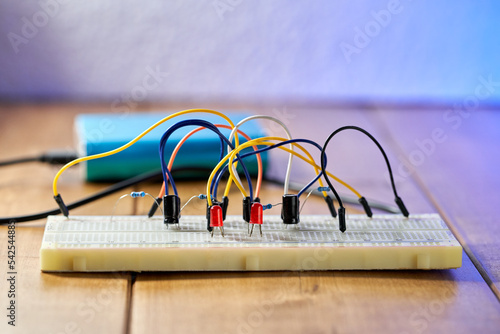 Breadboard with electrical elements, on a wooden table. photo