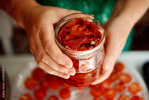 Woman in her kitchen preparing sun-dried tomatoes