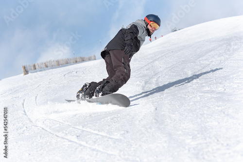 Young man snowboarding on the slopes of a ski resort